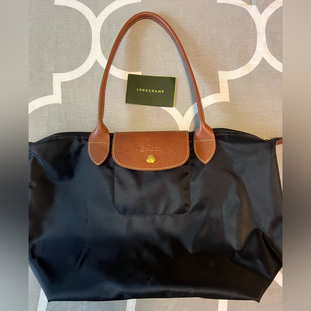 Black Longchamp Le Pliage Tote in old small/new medium.